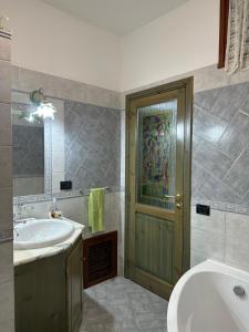 a bathroom with a sink and a tub and a door at Appartamento Picasso in Cala Gonone