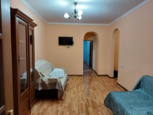 a room with a bed and a couch and a tv at Апартаменты Denis in Gudauta