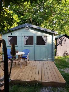 a blue shed with a table on a deck at La cabane de Mimi la Sardine in Saint-Gervais en-Belin