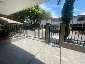 una cerca de metal con una puerta en un patio en Apartamento con aire acondicionado al lado de la Unidad Deportiva de Belén y a 10 minutos de Plaza Mayor - 2, en Medellín