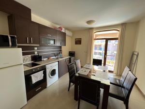 a kitchen with a table and a kitchen with a stove top oven at Camping Gradina Garden Beach b33 in Chernomorets