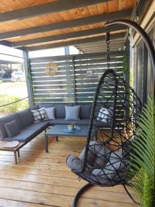 eine Veranda mit einer Schaukel auf einer Terrasse in der Unterkunft Luxury mobile home LA ISLA BONITA, Terra Park SpiritoS in Kolan