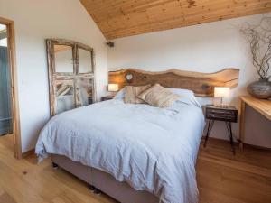 a bedroom with a large bed with a wooden headboard at Beachside chalet 3 Cormorant with access to beach in Cowes