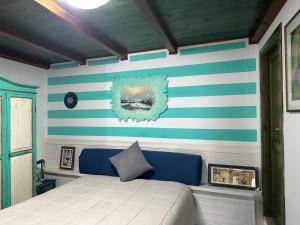 a bedroom with a bed with blue and white stripes at Appartamento Picasso in Cala Gonone