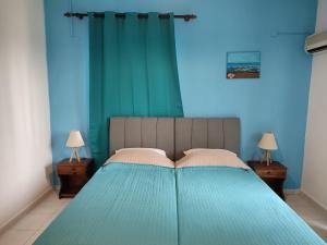 a blue bedroom with a bed with two lamps at Dolphin Apartments in Faliraki
