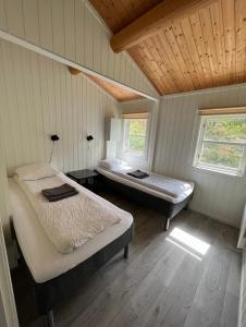 a bedroom with two beds and two windows at Nothaugen AS in Nordheim