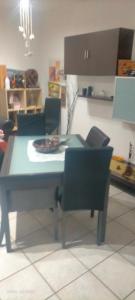 クアルトゥ・サンテーレナにあるCasa Loiのダイニングルームテーブル、椅子、青いテーブル、チェアトップが備わります。