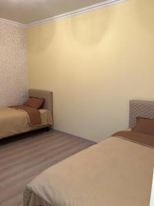 a bedroom with two beds and a wall at Roman's guest house in Garni in Garni
