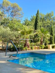 een zwembad in een tuin met bomen bij La Magistrale in Lorgues