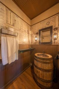 a bathroom with a barrel sink and a mirror at Miners Cabin #3 -Two Double Beds - Private Balcony - Walk to the Action in Tombstone