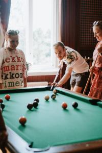 a group of people playing a game of pool at Gammelgård Pizza & Padel Resort in Nauvo