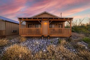 a log home with a deck on a rocky yard at Miners Cabin #3 -Two Double Beds - Private Balcony - Walk to the Action in Tombstone