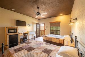 a hotel room with two beds and a kitchen and a living room at Miners Cabin #3 -Two Double Beds - Private Balcony - Walk to the Action in Tombstone