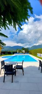 a swimming pool with two chairs and a table and chairs at Sport Manca Garni Hotel in Radovljica