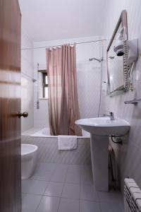 a white bathroom with a sink and a shower at Hotel Verde Pinho Bed&Breakfast in São Pedro de Moel