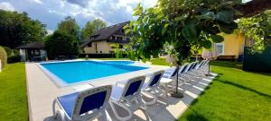 a group of chairs sitting next to a swimming pool at Sport Manca Garni Hotel in Radovljica