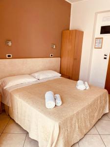 duas camas num quarto de hotel com toalhas em Hotel Favorita em Cesenatico