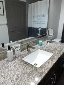 a bathroom counter with a sink and a mirror at Comfy Abode near Bush Airport in Houston