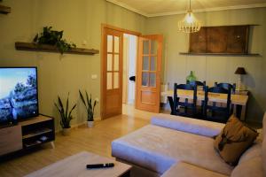a living room with a couch and a dining room at Apartamento Zaranda in Daimiel