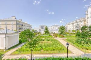 un jardin au milieu d'une ville avec des bâtiments dans l'établissement Cosy Yellow - Disney 15min walk - JO 30 min- Free Parking, à Serris