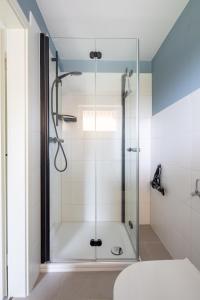 una ducha con puerta de cristal en un baño en Ferienhaus Annika in Schillig-Horumersiel mit 8 modernen Wohnungen, en Schillig 162 fotos más