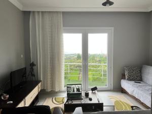 a living room with a couch and a large window at Mirayim Apart & Otel in Ardeşen