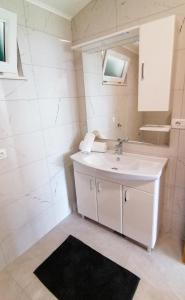 a white bathroom with a sink and a mirror at Villa Tri sulara in Kremena