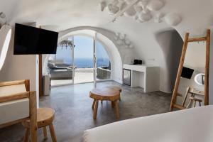 Schlafzimmer mit einem Bett und Meerblick in der Unterkunft Theano Cave Suites & Villas in Imerovigli