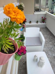 um quarto com uma mesa branca com flores e um banco em La Rosa BLUtique Guesthouse - Boutique apartment near Como em Lucino