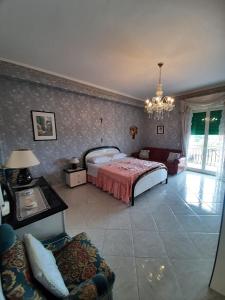 a bedroom with a bed and a couch and a chandelier at Maremonti in Zafferana Etnea