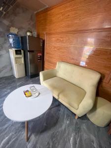 Centralhome 2 في Plei Brêng: غرفة معيشة مع أريكة وطاولة وكرسي
