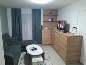 un piccolo soggiorno con divano e TV di Apartmani BET Gradačac 1 Maj broj 24 a Gradačac