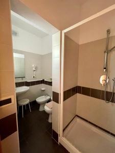 a bathroom with a shower and a toilet and a sink at Hotel Favorita in Cesenatico