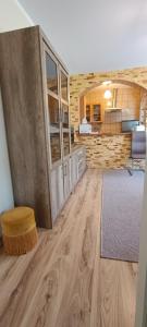 a living room with a wooden floor and a kitchen at Willa Dworek Skalar in Ustronie Morskie