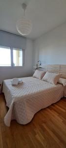 a bedroom with a large bed with a large white bedspread at Litoral beach in Málaga