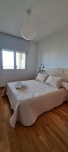 a bedroom with a large bed with a white bedspread at Litoral beach in Málaga
