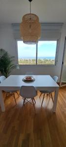 a white table and chairs in a room with a window at Litoral beach in Málaga