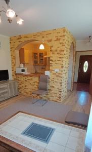 a living room with a stone wall and a chair at Willa Dworek Skalar in Ustronie Morskie