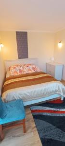 sypialnia z dużym łóżkiem i niebieskim stołkiem w obiekcie Willa Dworek Skalar w mieście Ustronie Morskie