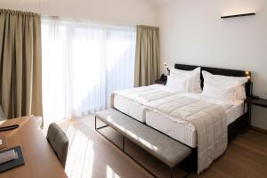 A bed or beds in a room at MÖRWALD Relais & Châteaux Hotel am Wagram