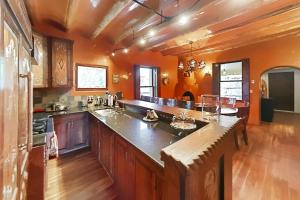 a large kitchen with orange walls and wooden floors at Antigua Inn in Santa Fe