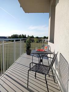 a patio with a table and chairs on a balcony at Apartament SEVENTH HEAVEN in Uniejow
