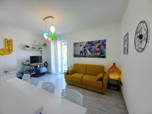 uma sala de estar com um sofá amarelo e uma mesa em La Rosa BLUtique Guesthouse - Boutique apartment near Como em Lucino