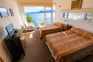 1 dormitorio con 2 camas y vistas al océano en La Casa del Lago Nahuel en San Carlos de Bariloche