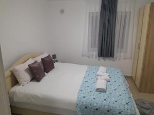 a bedroom with a bed with towels on it at Apartmani BET Gradačac 1 Maj broj 24 in Gradačac
