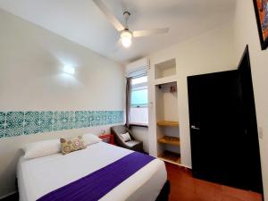 a small bedroom with a bed and a window at Casa Puerto Bonito & Private Coworking in Puerto Escondido