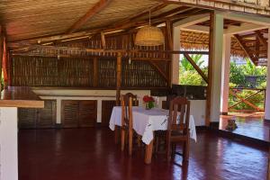 a dining room with a table and chairs in a building at Villa MILENA in Nosy Be