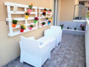 um quarto com cadeiras brancas e vasos de plantas em La Rosa BLUtique Guesthouse - Boutique apartment near Como em Lucino