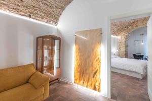 Calderai 82 suites 1 e 2 في باليرمو: غرفة معيشة مع أريكة وسرير