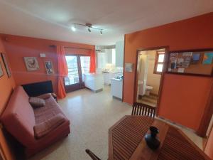 een woonkamer met oranje muren en een bank bij FINCA LA JORADITA in Tamaduste